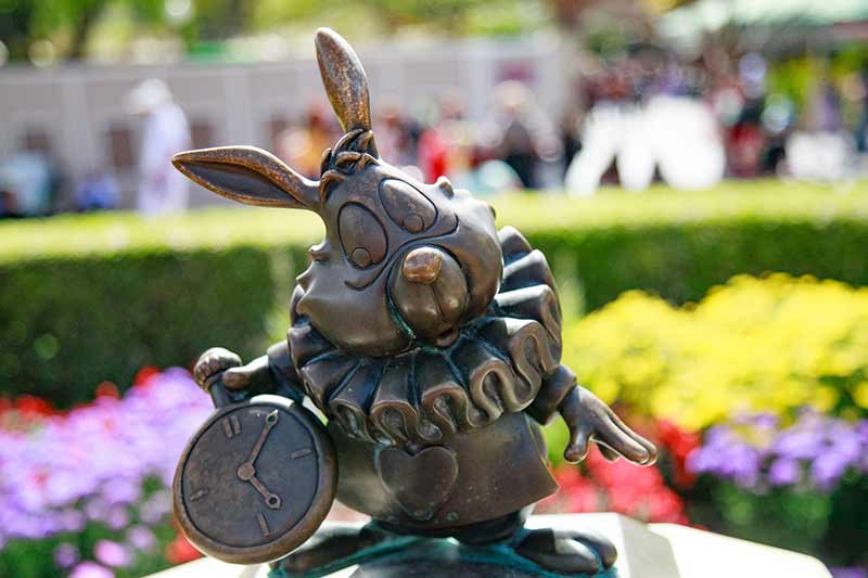 Statue at Disney of the White Rabbit looking at his watch.