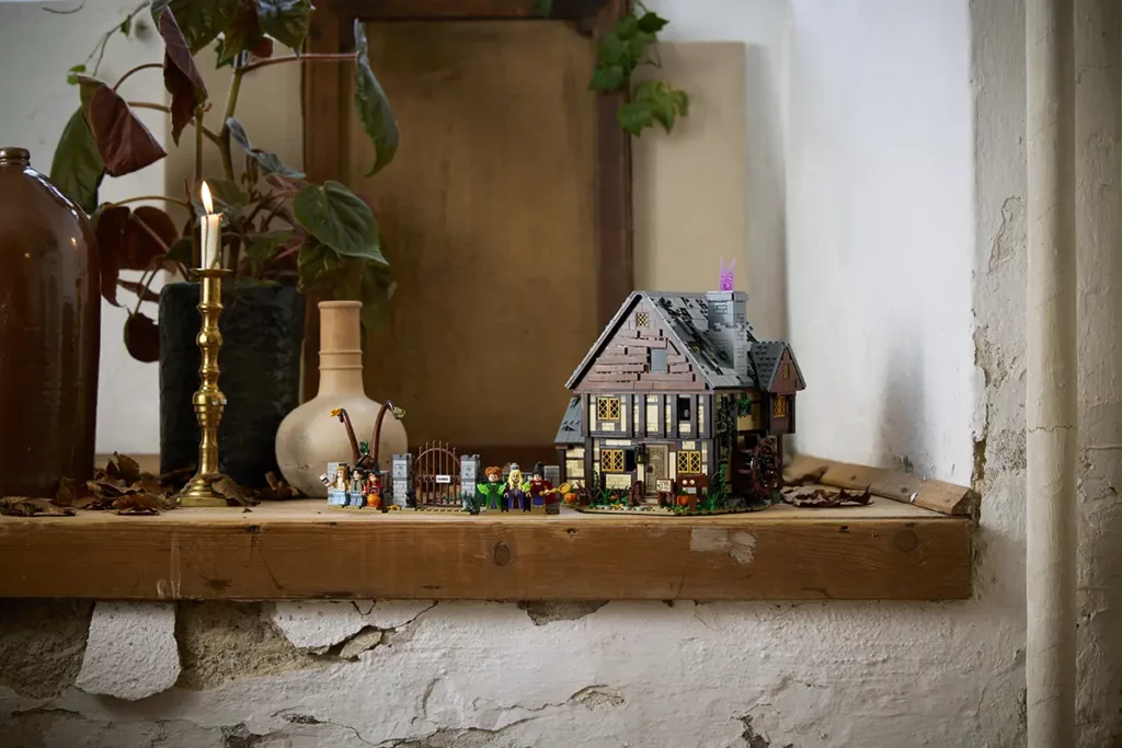 LEGO Ideas Disney Hocus Pocus: The Sanderson Sisters’ Cottage set built and displayed on wooden shelf.