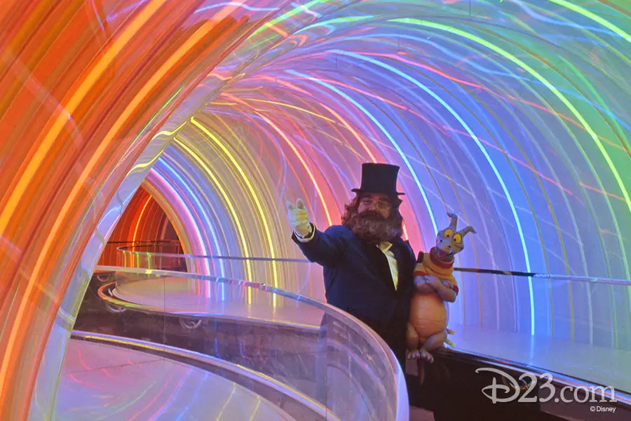 Dreamfinder and Figment walk through rainbow tunnel at Walt Disney World